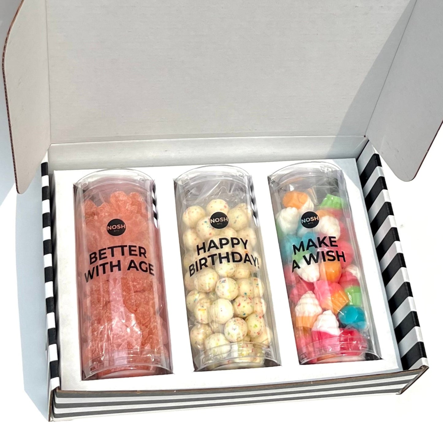 Three tubes filled with colorful candies and text in a white box with black and white striped exterior