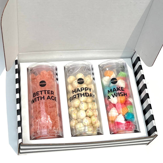 Three tubes filled with colorful candies and text in a white box with black and white striped exterior