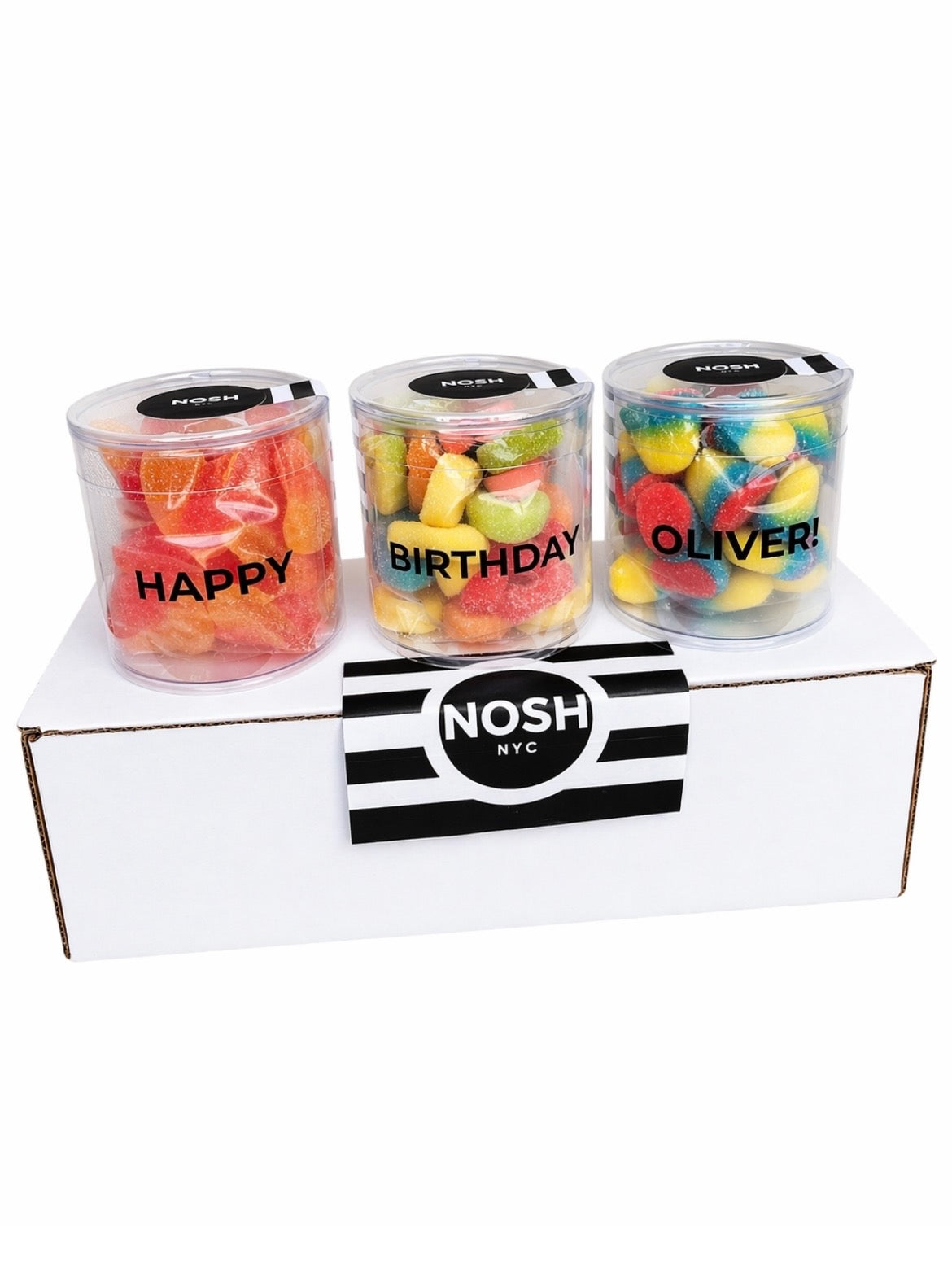 Three small jars of gummy bears with personalized names on a white box labeled 'Nosh NYC'.